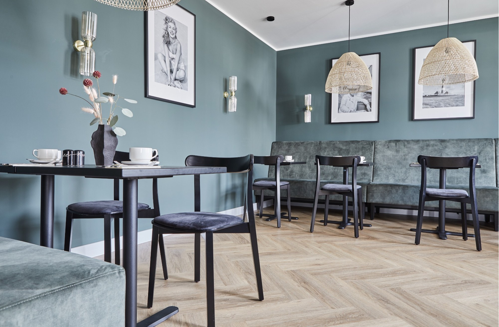 Farb- und Materialkonzept mit grünen Wänden und dunklen Stühlen im Hotel Binzer Hof in Binz