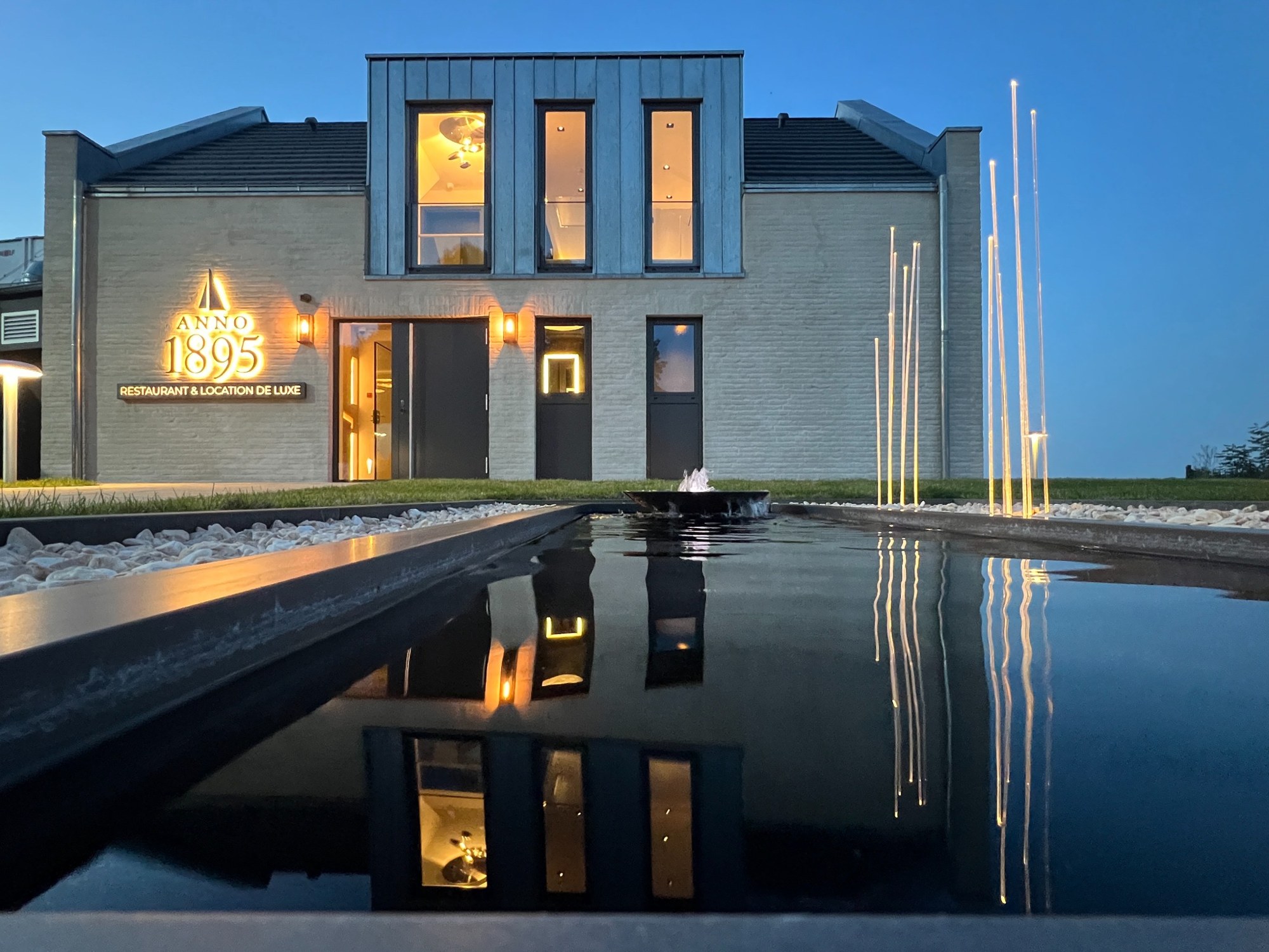 Außenansicht zur blauen Stunde mit Wasserbecken – Strandhotel Marienbad